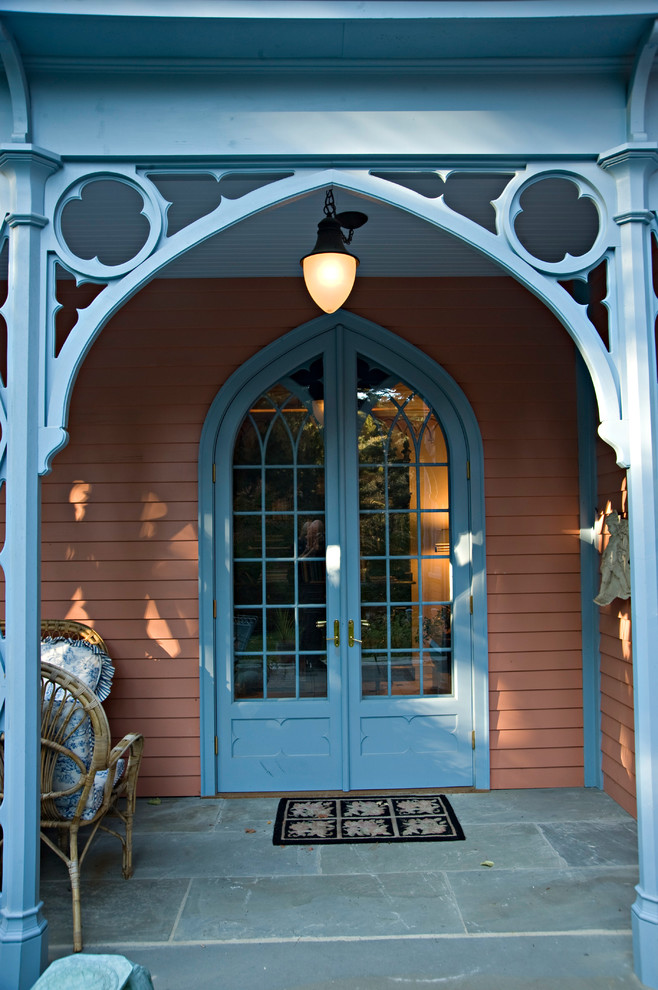 Inspiration för små eklektiska ingångspartier, med bruna väggar, skiffergolv, en dubbeldörr och en blå dörr