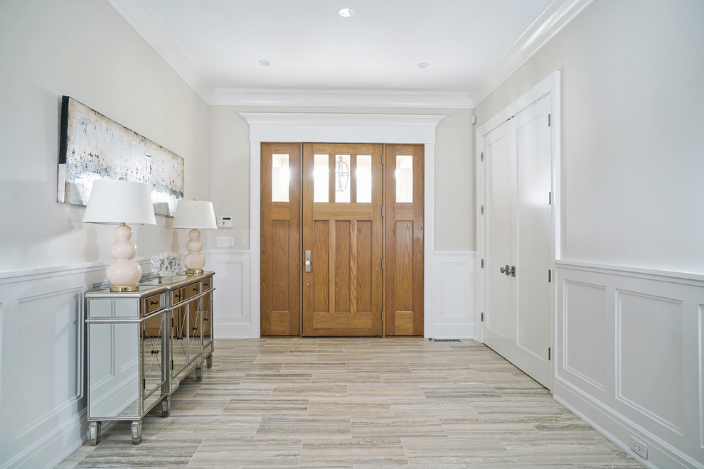 Idee per una porta d'ingresso classica di medie dimensioni con pareti marroni, pavimento in laminato, una porta singola, una porta in legno chiaro e pavimento marrone