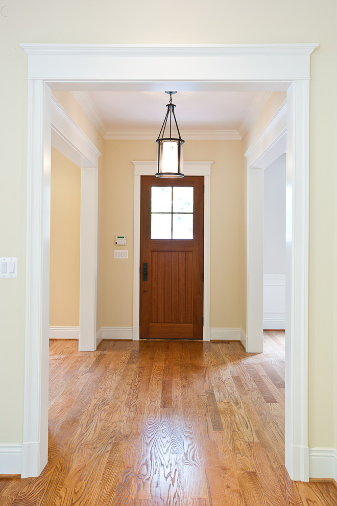 Inspiration for a traditional foyer in DC Metro with beige walls, medium hardwood flooring, a single front door and a medium wood front door.