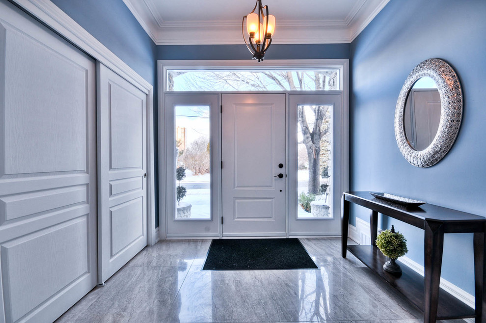 Ejemplo de puerta principal clásica renovada de tamaño medio con paredes azules, suelo de mármol, puerta simple y puerta blanca