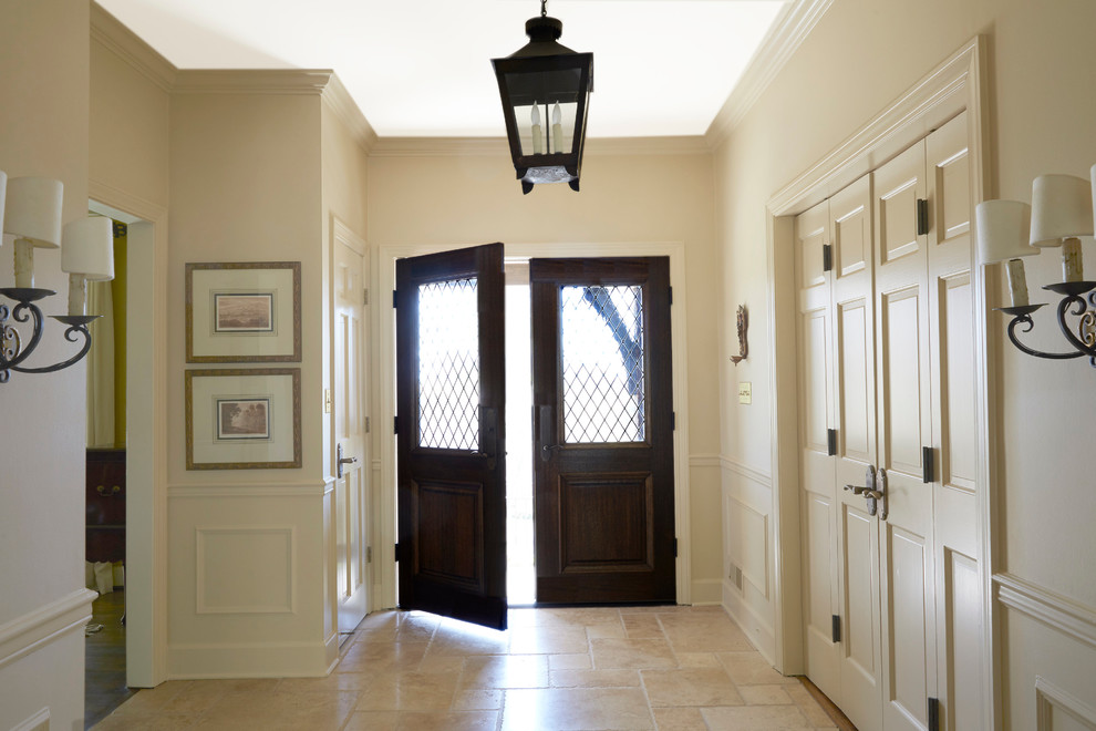 Diseño de entrada tradicional de tamaño medio con suelo de travertino, puerta doble y puerta de madera oscura