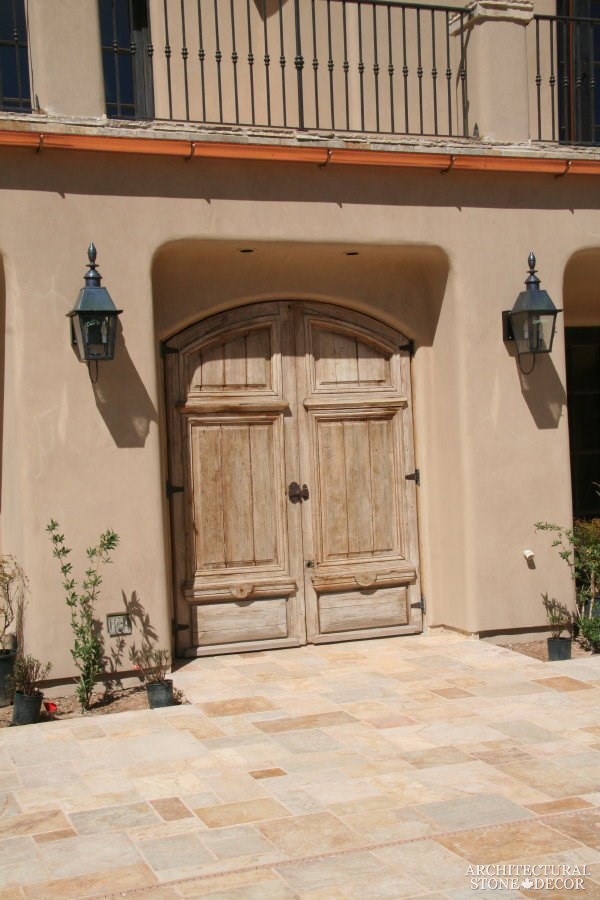 Foto di una porta d'ingresso mediterranea di medie dimensioni con pavimento in pietra calcarea