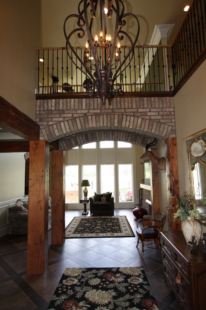Example of a large classic brown floor foyer design in New Orleans with beige walls and a dark wood front door