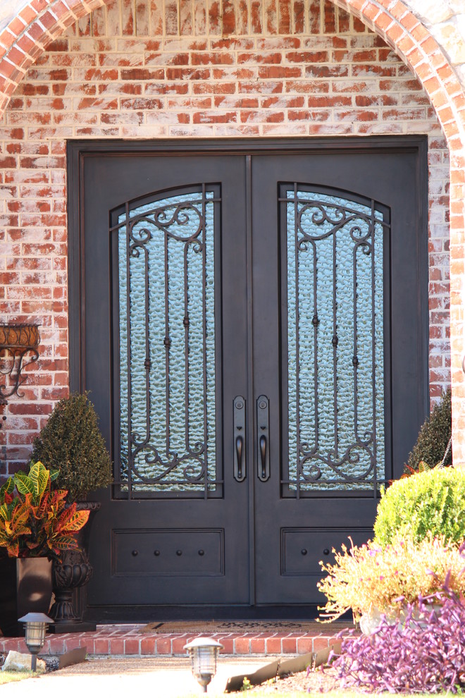 На фото: входная дверь в классическом стиле с двустворчатой входной дверью и металлической входной дверью