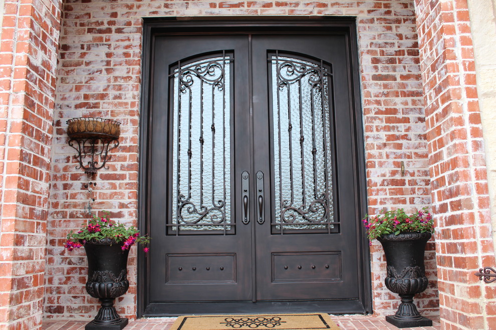 На фото: входная дверь в классическом стиле с двустворчатой входной дверью и металлической входной дверью с