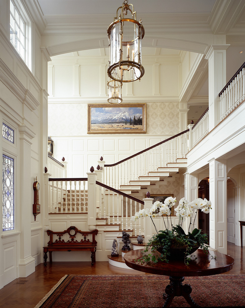 Cette image montre un hall d'entrée traditionnel avec un mur blanc et parquet foncé.