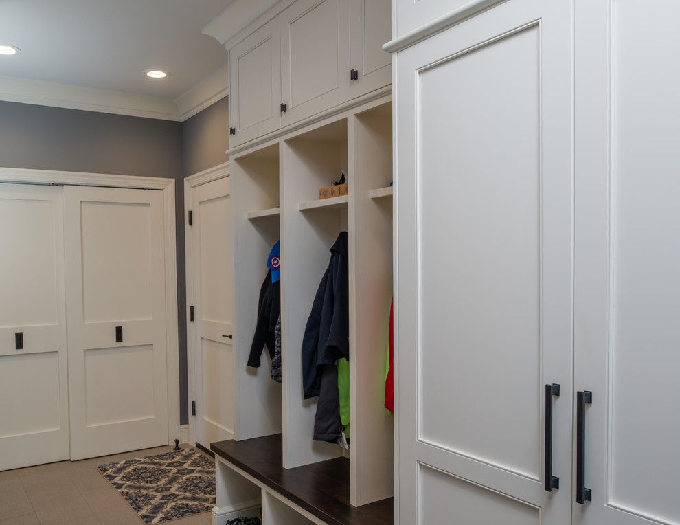 This is an example of a large traditional boot room in Detroit with grey walls, ceramic flooring, a single front door and a white front door.