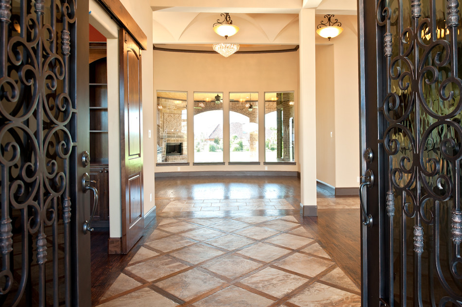 Ispirazione per un grande ingresso tradizionale con pareti beige, pavimento con piastrelle in ceramica, una porta a due ante e una porta in metallo