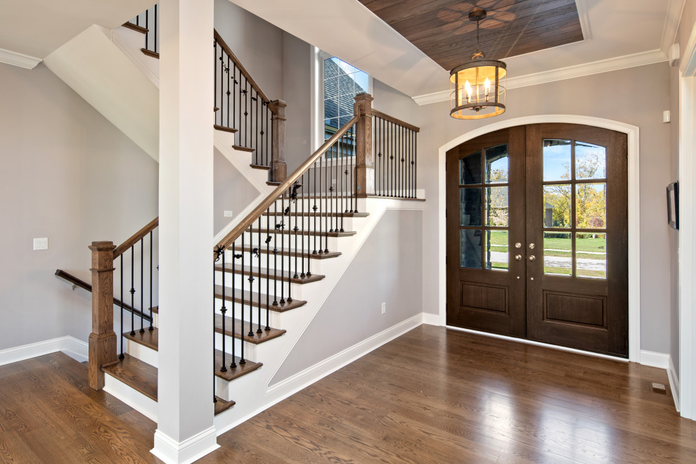 Example of a mid-sized transitional medium tone wood floor and brown floor entryway design in Cincinnati with gray walls and a medium wood front door
