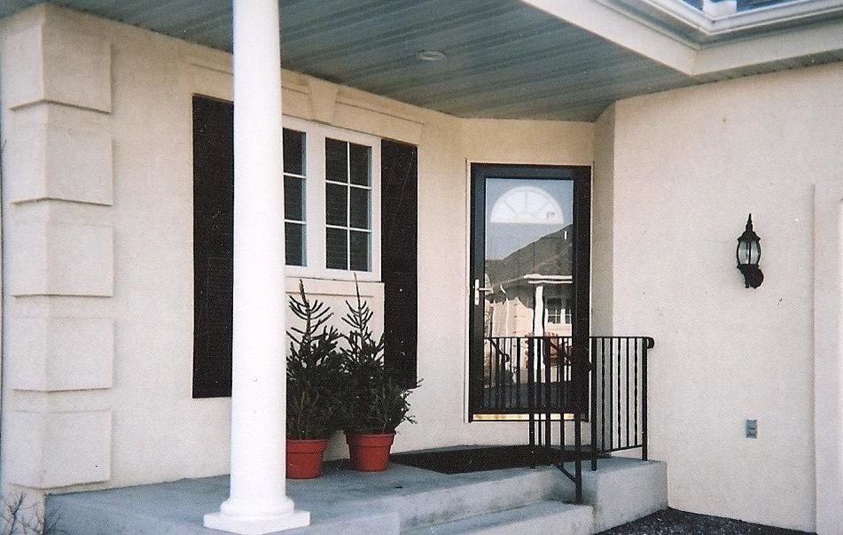 Réalisation d'une porte d'entrée de taille moyenne avec un mur marron, sol en béton ciré, une porte simple et une porte blanche.