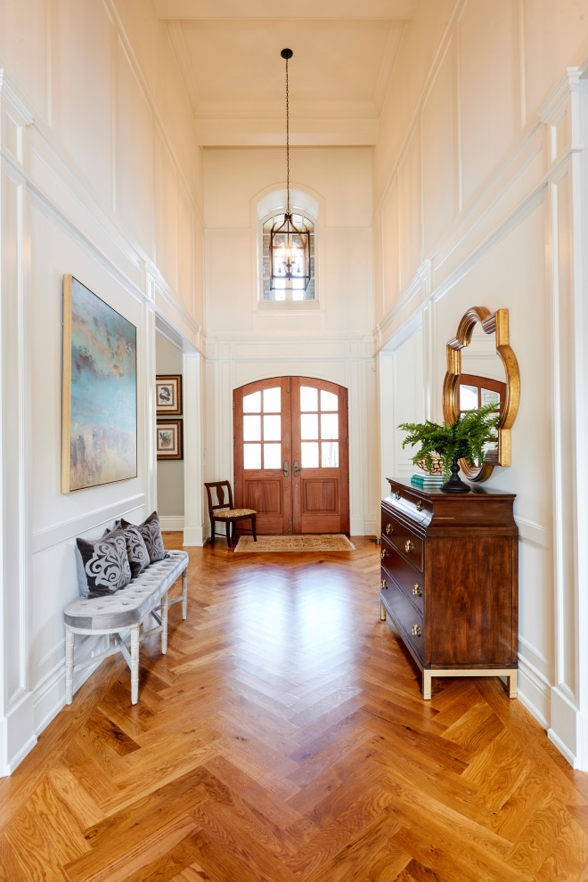 Inspiration for a traditional hallway in Toronto with white walls, medium hardwood flooring, a double front door, a medium wood front door and brown floors.