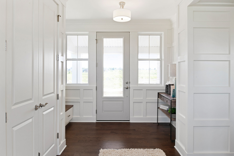 Ispirazione per un grande ingresso chic con pareti bianche, pavimento in legno massello medio, una porta singola e una porta grigia