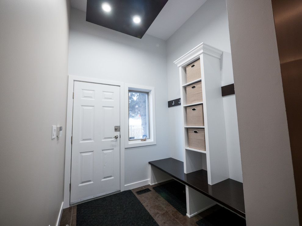 This is an example of a medium sized classic boot room in Edmonton with white walls, ceramic flooring, a single front door and a white front door.