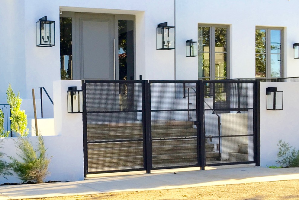 Esempio di una porta d'ingresso minimalista di medie dimensioni con pareti bianche, pavimento in cemento, una porta singola e una porta grigia