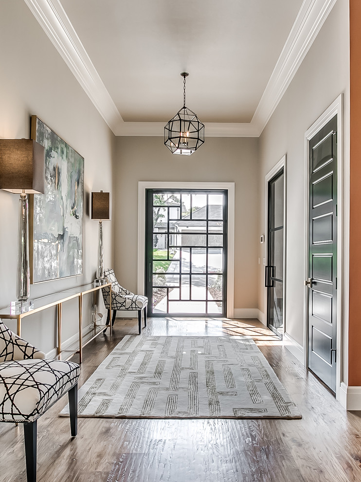 Klassisches Foyer mit grauer Wandfarbe, braunem Holzboden, Drehtür, Haustür aus Glas und braunem Boden in Oklahoma City