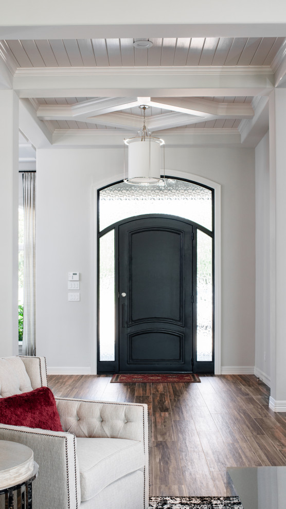This is an example of a medium sized traditional front door in Houston with white walls, porcelain flooring, a single front door, a black front door, brown floors and a timber clad ceiling.