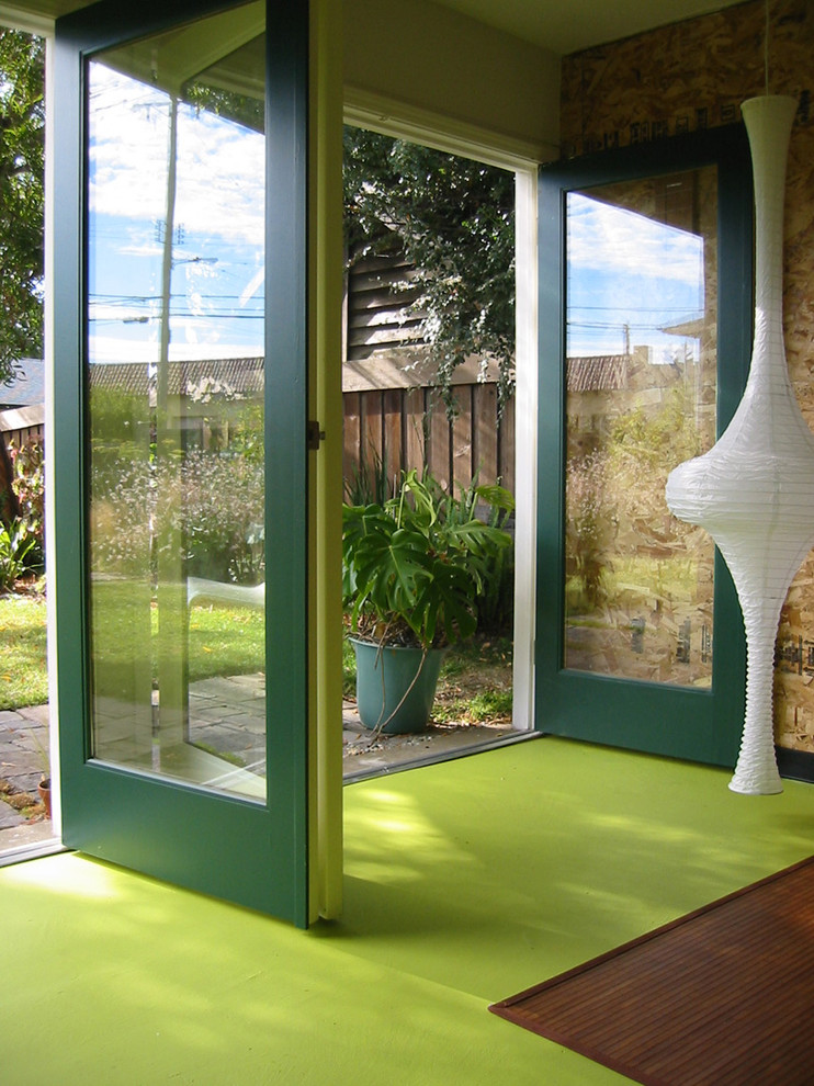 Réalisation d'une porte d'entrée design avec une porte verte et un sol vert.