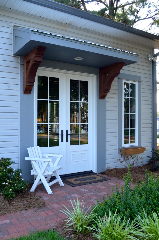 Rustik inredning av en liten ingång och ytterdörr, med en dubbeldörr och en vit dörr