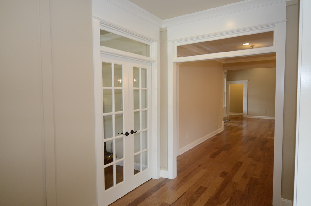 Diseño de hall clásico pequeño con paredes beige, suelo de madera en tonos medios, puerta simple y puerta de madera oscura