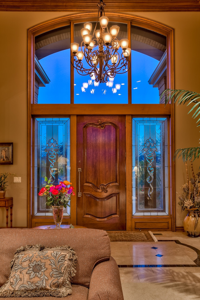 Großes Klassisches Foyer mit brauner Wandfarbe, Porzellan-Bodenfliesen, Einzeltür und hellbrauner Holzhaustür in Omaha