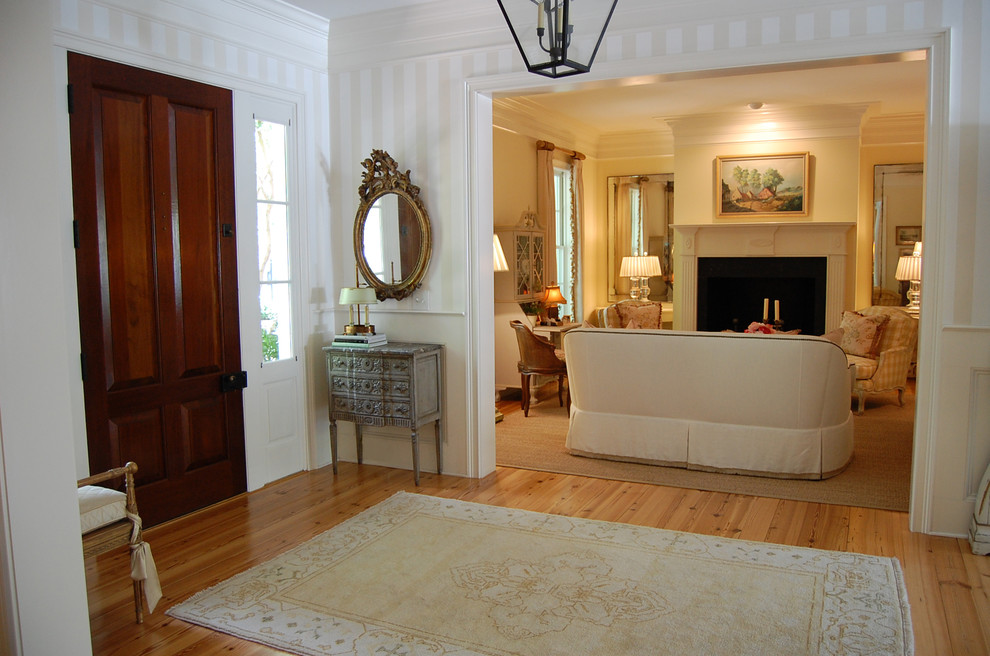 На фото: фойе среднего размера в классическом стиле с белыми стенами, паркетным полом среднего тона, одностворчатой входной дверью, входной дверью из темного дерева и коричневым полом
