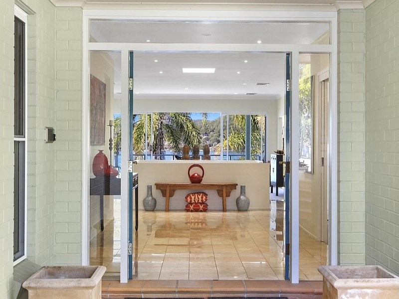 シドニーにある中くらいなエクレクティックスタイルのおしゃれな玄関ドア (緑の壁、磁器タイルの床、青いドア、ベージュの床) の写真