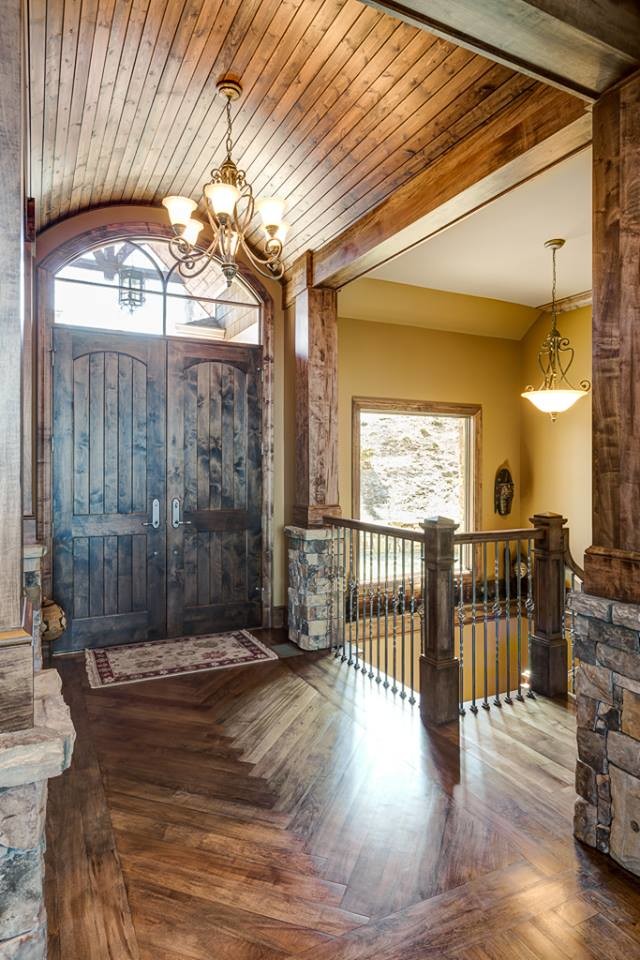 Diseño de puerta principal rural de tamaño medio con paredes beige, suelo de madera oscura, puerta doble, puerta de madera oscura y suelo marrón