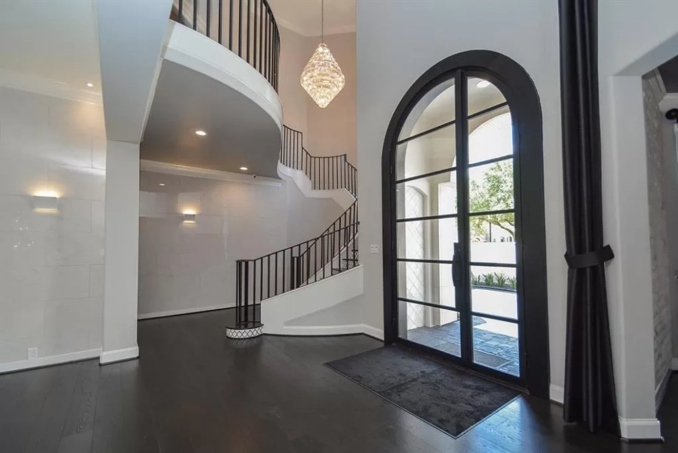 Inspiration for a large mediterranean foyer in Houston with grey walls, dark hardwood flooring, a single front door, a glass front door and black floors.