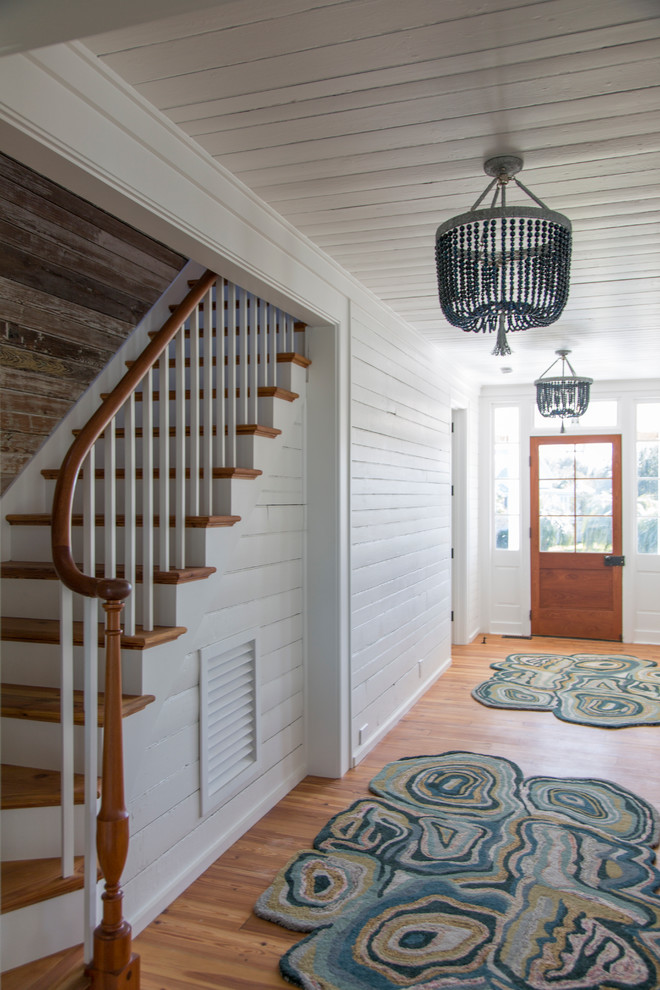 Idee per un corridoio stile marinaro con pareti bianche, pavimento in legno massello medio, una porta singola e una porta in legno bruno