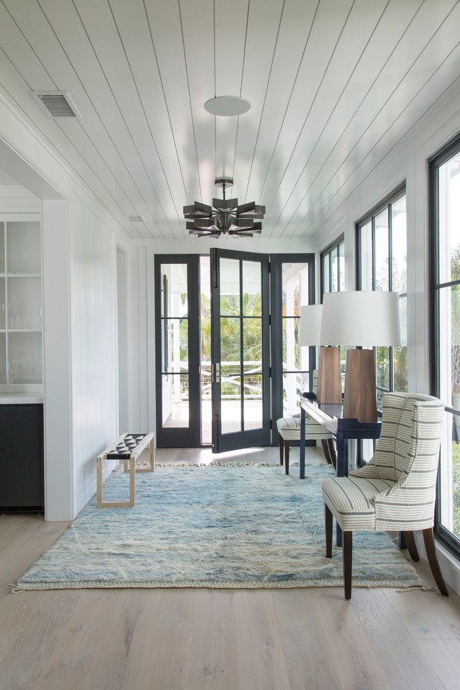 Maritime Haustür mit weißer Wandfarbe, hellem Holzboden, Einzeltür und schwarzer Haustür in Charleston