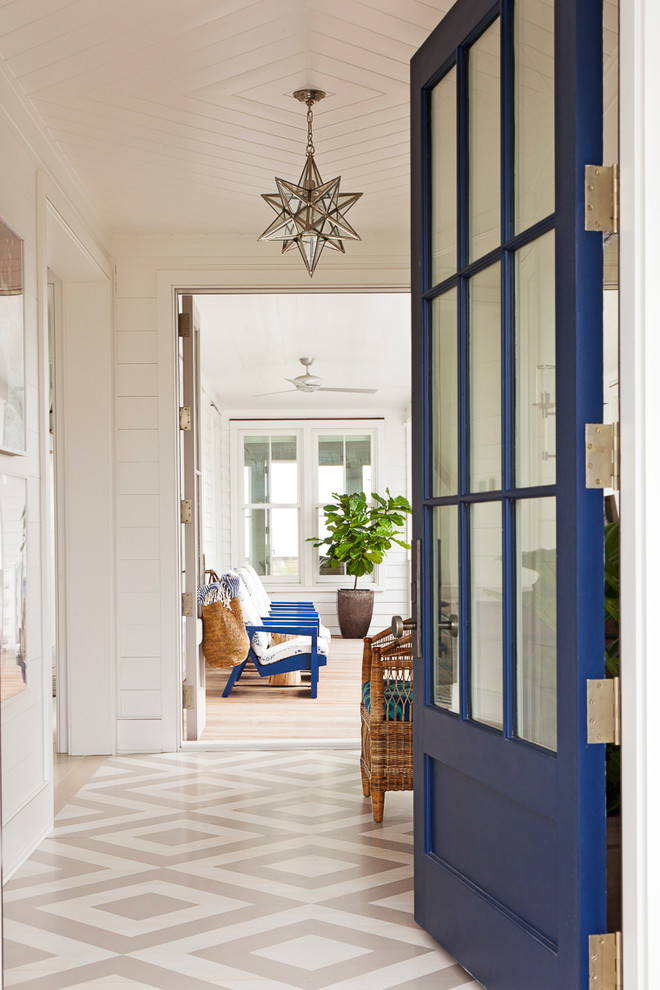 Maritime Haustür mit weißer Wandfarbe, gebeiztem Holzboden, Einzeltür und blauer Haustür in Charleston