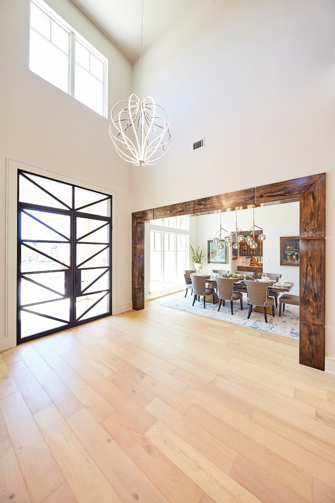 Inspiration for a large contemporary light wood floor and beige floor entryway remodel in Dallas with white walls and a glass front door