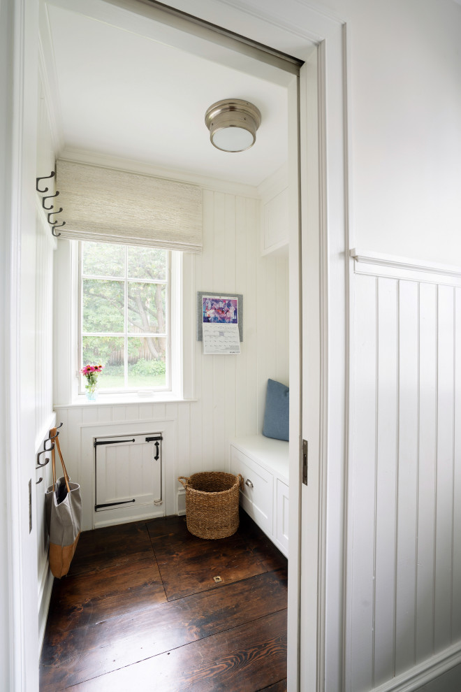 Example of a small classic dark wood floor and wall paneling mudroom design in Philadelphia with white walls