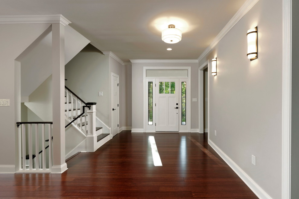 Exemple d'un hall d'entrée craftsman de taille moyenne avec un mur gris, parquet en bambou, une porte simple, une porte blanche et un sol marron.