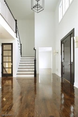 Design ideas for a large traditional foyer in New York with white walls, dark hardwood flooring, a single front door and a dark wood front door.