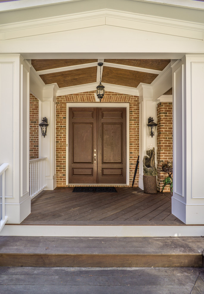 Ejemplo de puerta principal clásica extra grande con paredes marrones, suelo de madera oscura, puerta doble y puerta de madera oscura