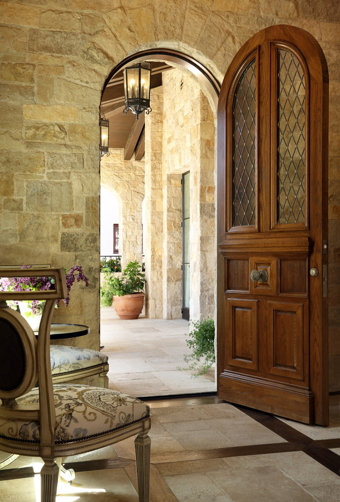 Idées déco pour un hall d'entrée méditerranéen avec une porte simple, une porte en bois foncé et un sol beige.
