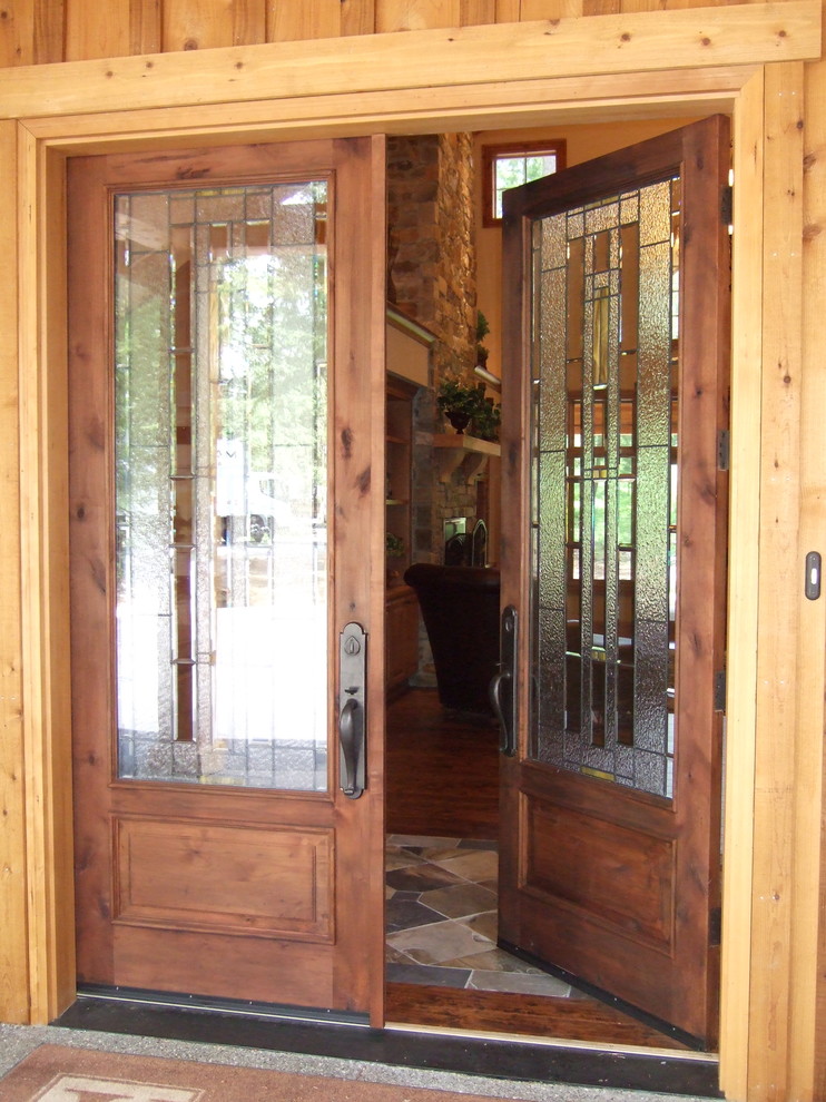 Réalisation d'une porte d'entrée design de taille moyenne avec un mur marron, parquet foncé, une porte double, une porte en bois foncé et un sol marron.