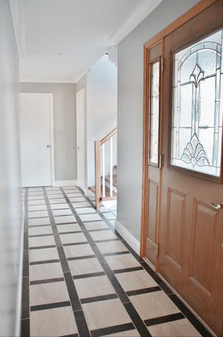 Idée de décoration pour une porte d'entrée minimaliste de taille moyenne avec un mur gris, parquet clair, une porte simple et une porte en bois clair.