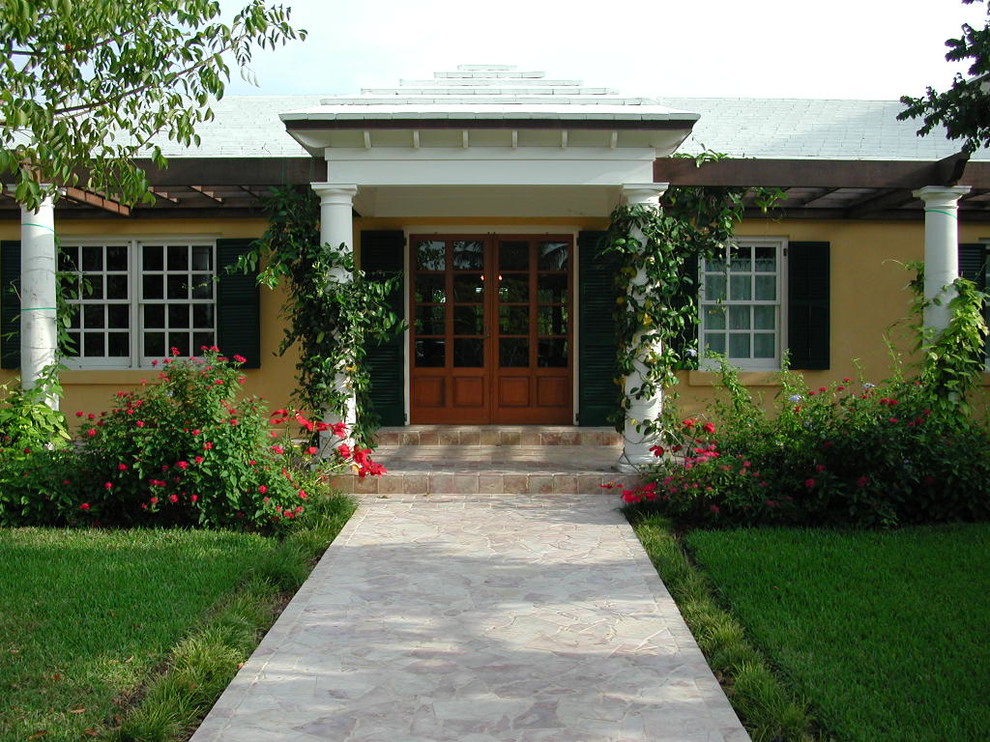 Geräumige Haustür mit gelber Wandfarbe, Kalkstein, Doppeltür und hellbrauner Holzhaustür in Miami