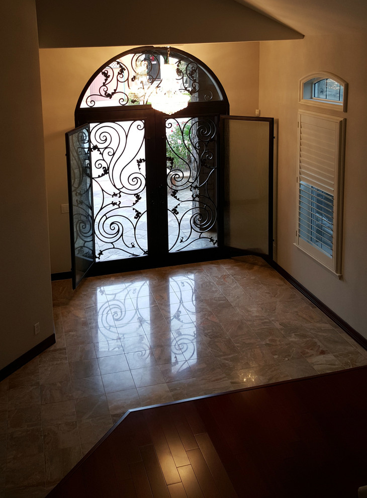 Идея дизайна: большая входная дверь в средиземноморском стиле с коричневыми стенами, полом из сланца, двустворчатой входной дверью и коричневой входной дверью