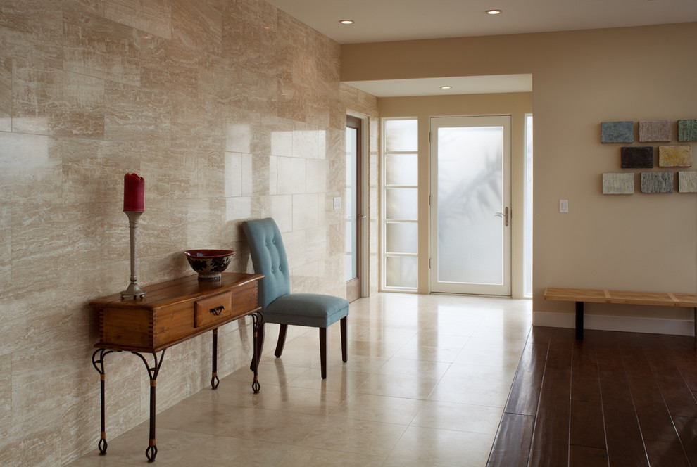 Example of a mid-sized trendy travertine floor entryway design in San Diego with beige walls and a glass front door