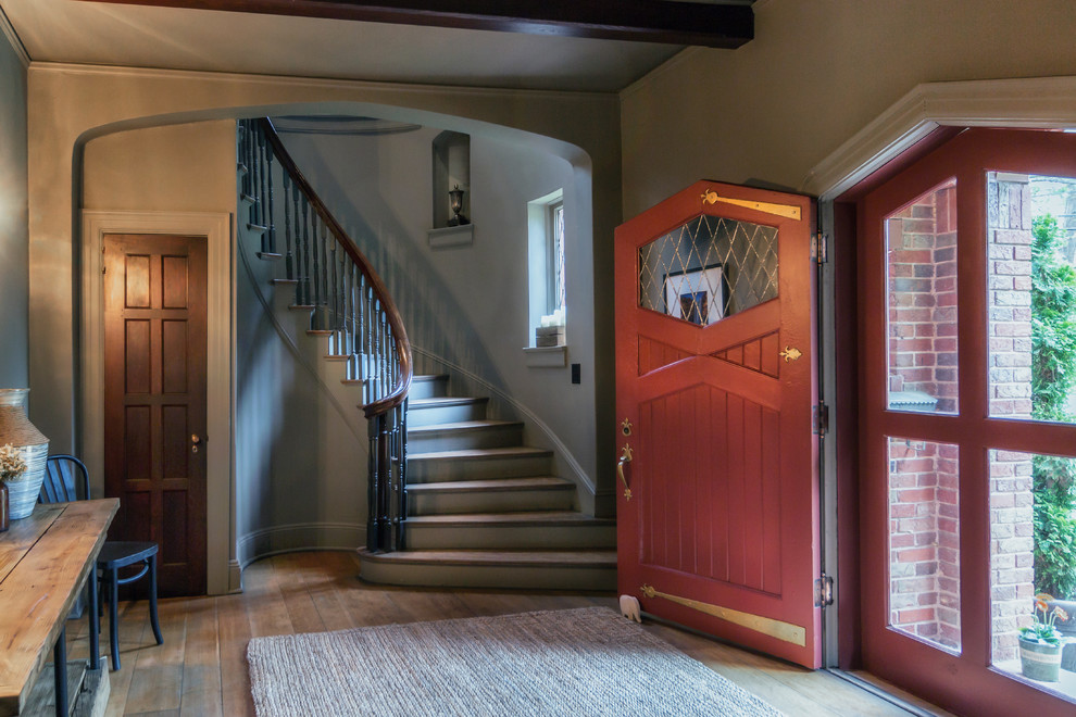 На фото: фойе в классическом стиле с серыми стенами, паркетным полом среднего тона, одностворчатой входной дверью, красной входной дверью и коричневым полом с