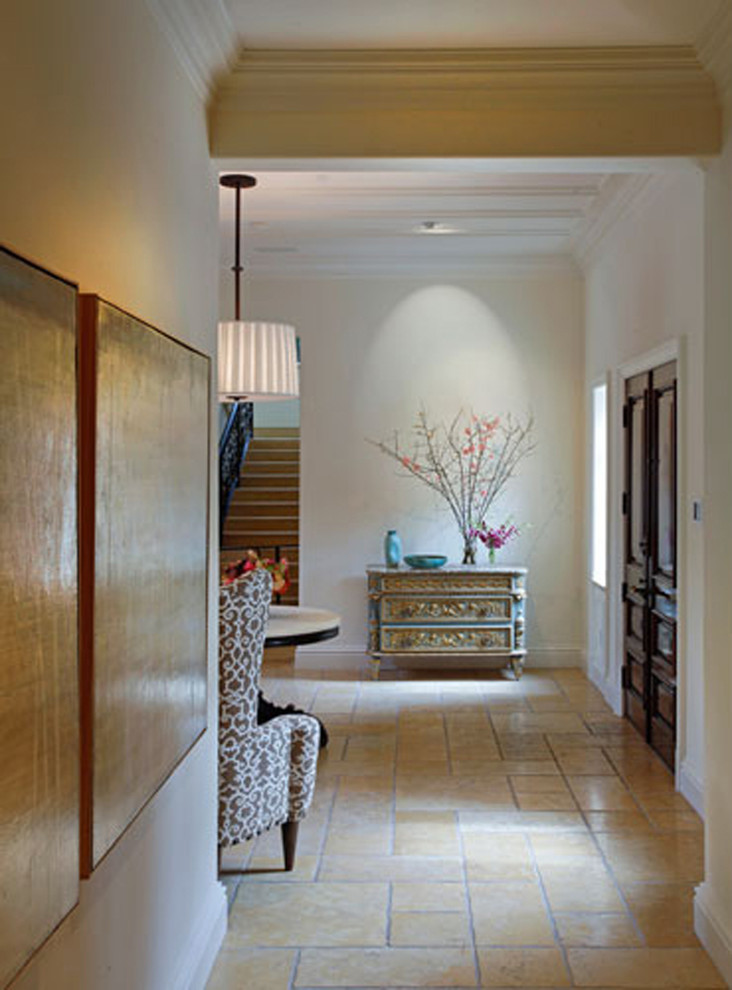Idée de décoration pour une grande entrée tradition avec un couloir, un mur blanc, tomettes au sol, une porte en bois foncé et un sol beige.
