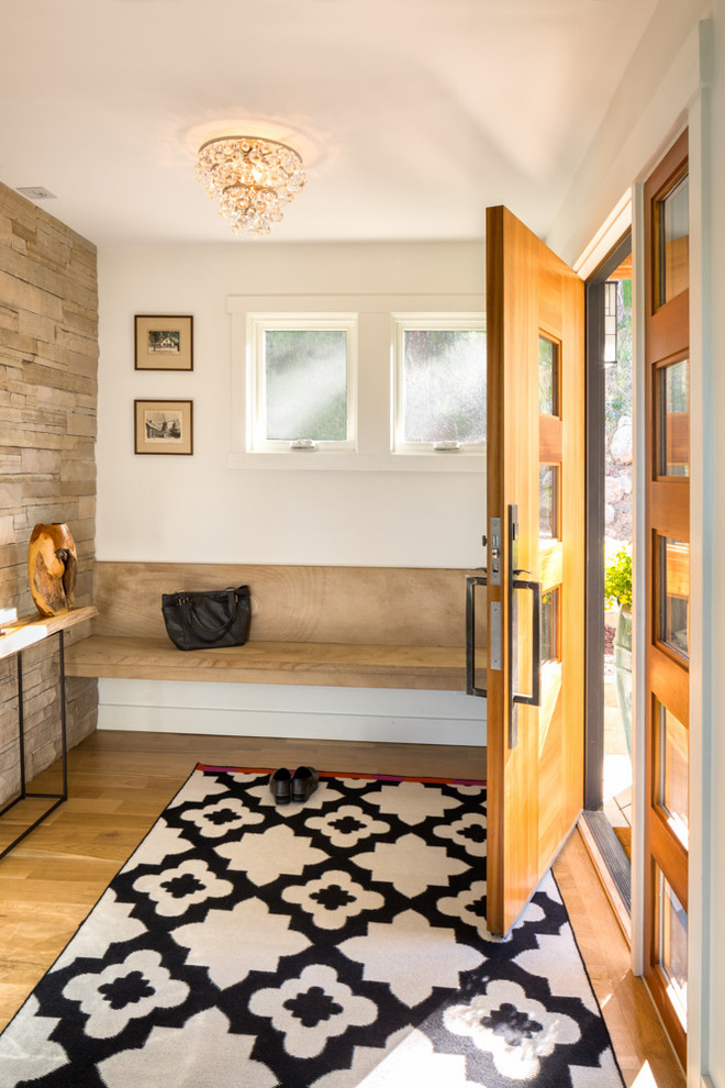Foto de distribuidor actual con paredes blancas, suelo de madera clara, puerta simple y puerta de madera clara