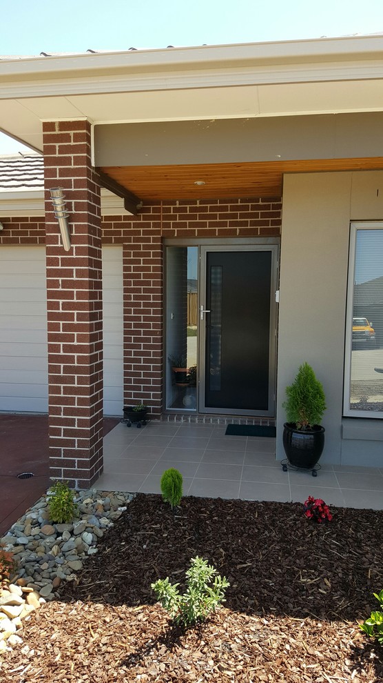 Immagine di una porta d'ingresso minimalista con una porta singola e una porta marrone