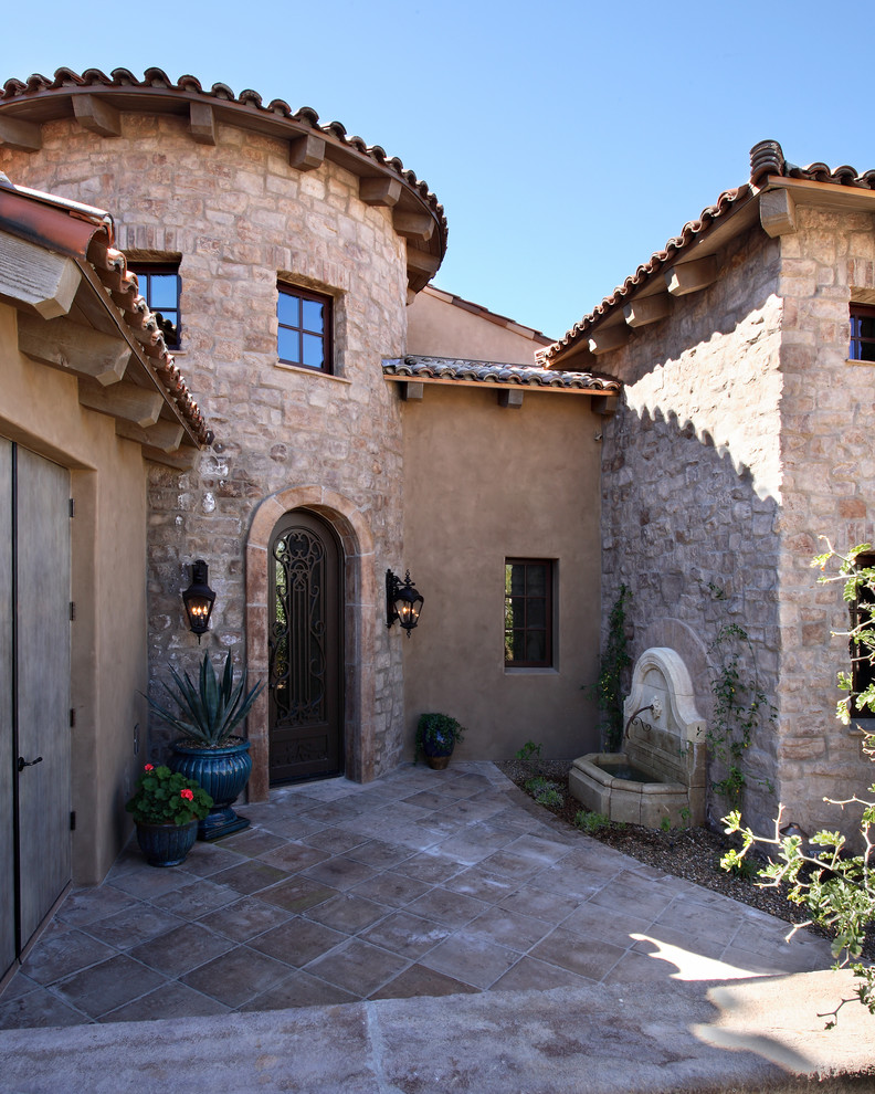 Inspiration for a mediterranean entrance in Phoenix with a single front door and a metal front door.