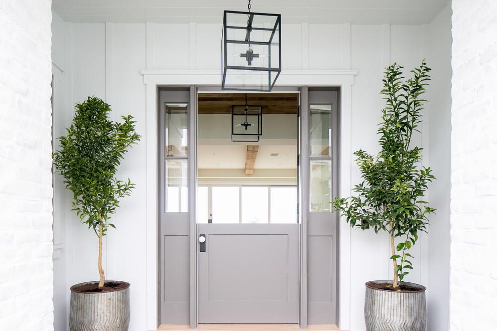 Esempio di una porta d'ingresso country di medie dimensioni con pareti bianche, una porta olandese e una porta grigia