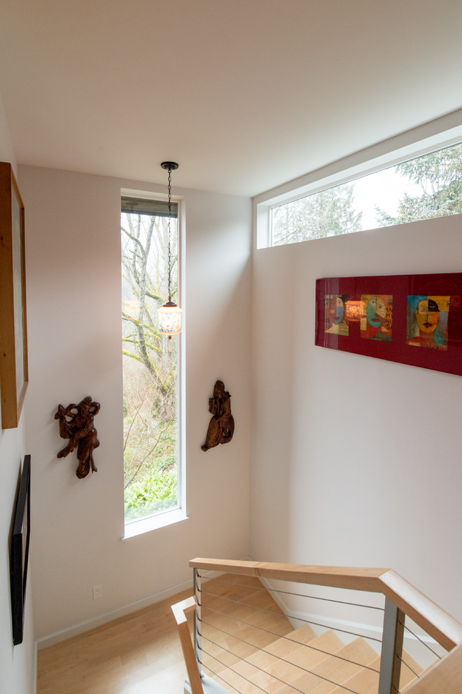 Ispirazione per un grande ingresso contemporaneo con pareti rosse, parquet chiaro, una porta singola, una porta in legno chiaro e pavimento marrone
