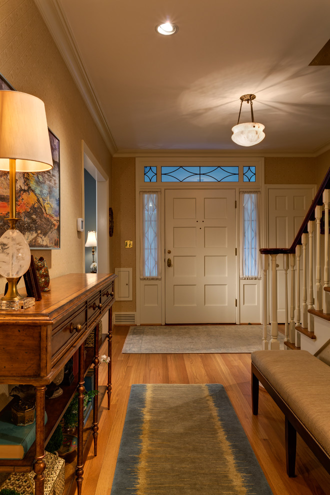 Ejemplo de puerta principal clásica grande con paredes beige, suelo de madera en tonos medios, puerta simple y puerta blanca